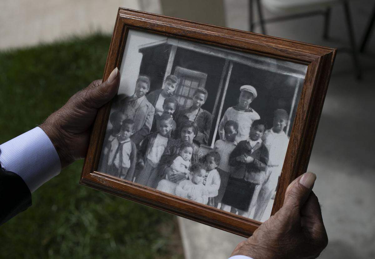 Robert Mann holds a photograph of his mother Cleora W. Mann and his siblings following her burial on Friday, May 1, 2020 in Louisburg, N.C. Mann, age 104, died from the coronavirus virus on Sunday, April 26. She was the mother of 16 children.