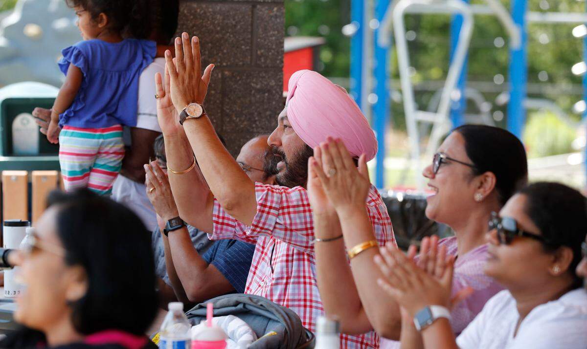 From left center, Jas Malhotra and his wife Neeti Malhotra, along with Raghu Bhogireddi, right, cheer on Morrisville during a match between the Morrisville Cardinals and the Atlanta Param Veers in the inaugural Toyota Minor League Cricket Championship at Church Street Park in Morrisville, N.C., Sunday, August 8, 2021.