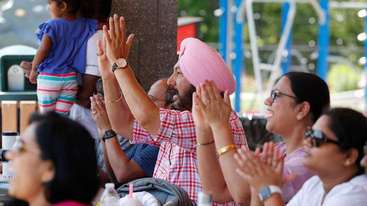 From left center, Jas Malhotra and his wife Neeti Malhotra, along with Raghu Bhogireddi, right, cheer on Morrisville during a match between the Morrisville Cardinals and the Atlanta Param Veers in the inaugural Toyota Minor League Cricket Championship at Church Street Park in Morrisville, N.C., Sunday, August 8, 2021.