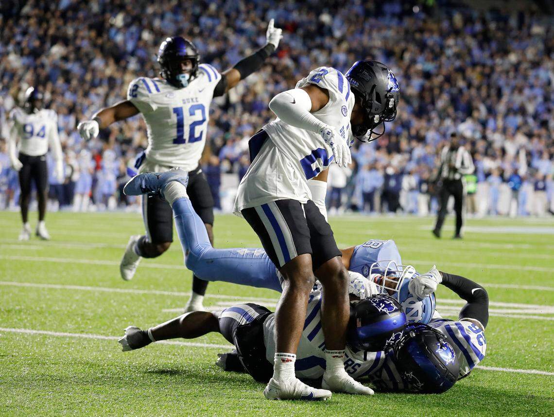 Duke’s Chandler Rivers (0) and Joshua Pickett (26) wrestle for the ball after a catch by North Carolina’s Bryson Nesbit with less than two minutes remaining in regulation of the Blue Devils’ 47-45 loss on Saturday, Nov. 11, 2023, at Kenan Stadium in Chapel Hill, N.C.