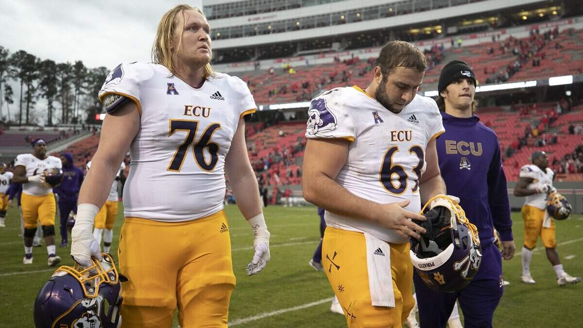 East Carolina’s Dalton Montgomery (76) and Jaison Fournet (63) leave the field following their 58-3 loss to N.C. State on Saturday, December 1, 2018 at Carter Finley Stadium in Raleigh, N.C.