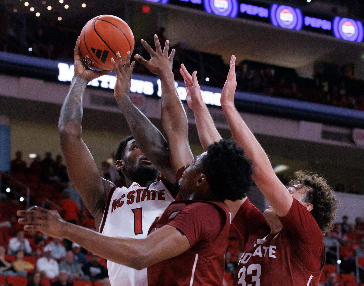 N.C. State’s Brandon Huntley-Hatfield shoots over Colgate’s Nicolas Louis-Jacques and Sam Wright during the second half of the Wolfpack’s 72-49 win at Lenovo Center on Monday, Nov. 18, 2024, in Raleigh, N.C.