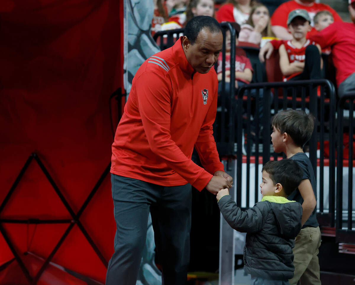 N.C. State head coach Kevin Keatts receives a fist bump from a young fan prior to the Wolfpack’s game against Rider on Sunday, Dec. 22, 2024, at Lenovo Center in Raleigh, N.C.