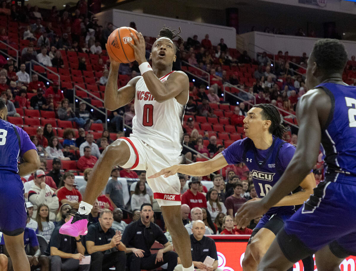 N.C. State’s DJ Horne drives past Abilene Christian’s Nasir DeGruy and Ali Abdou Dibba during the first half of the Wolfpack’s game on Friday, Nov. 10, 2023, at PNC Arena in Raleigh, N.C.