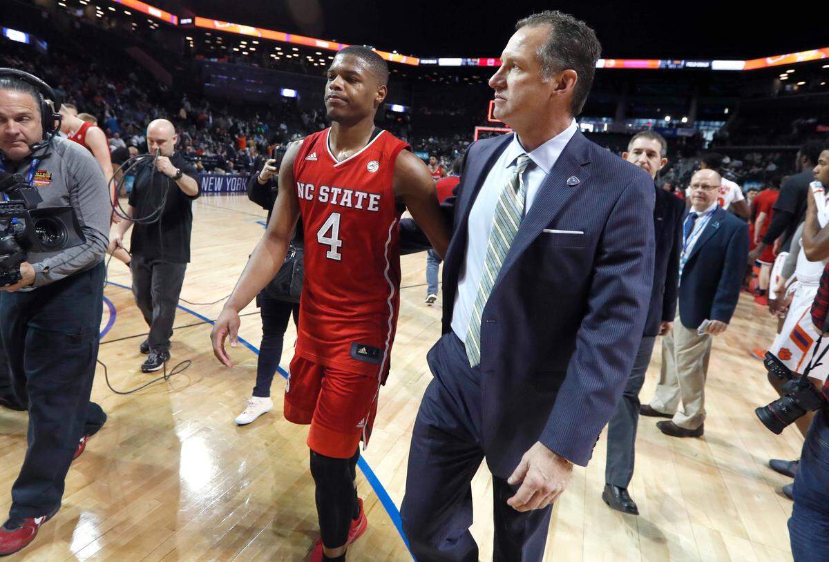 N.C. State’s head coach Mark Gottfried walks off the floor with Dennis Smith Jr. (4) after Clemson’s 75-61 victory over N.C. State in the 2017 New York Life ACC Tournament at the Barclays Center in Brooklyn, N.Y., Tuesday, March 7, 2017.