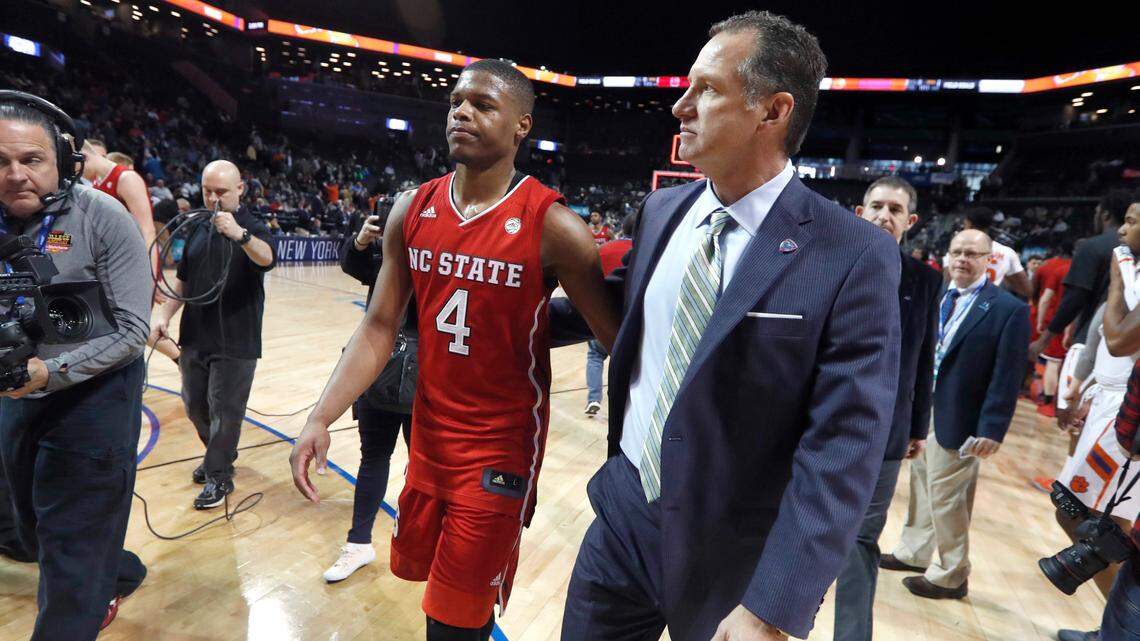 N.C. State’s head coach Mark Gottfried walks off the floor with Dennis Smith Jr. (4) after Clemson’s 75-61 victory over N.C. State in the 2017 New York Life ACC Tournament at the Barclays Center in Brooklyn, N.Y., Tuesday, March 7, 2017.