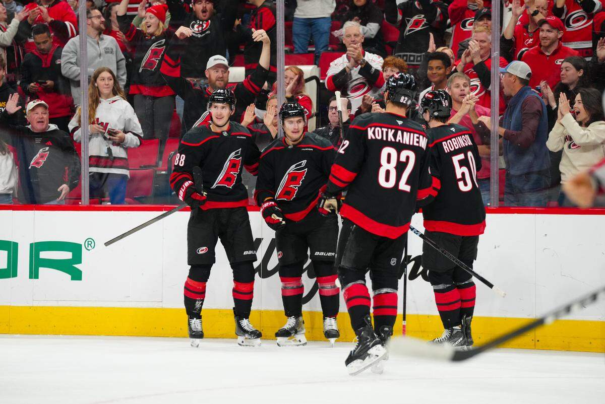 Carolina Hurricanes defenseman Dmitry Orlov (7) celebrates his goal with center Martin Necas (88) left wing Eric Robinson (50) and center Jesperi Kotkaniemi (82) against the Washington Capitals during the first period at Lenovo Center.