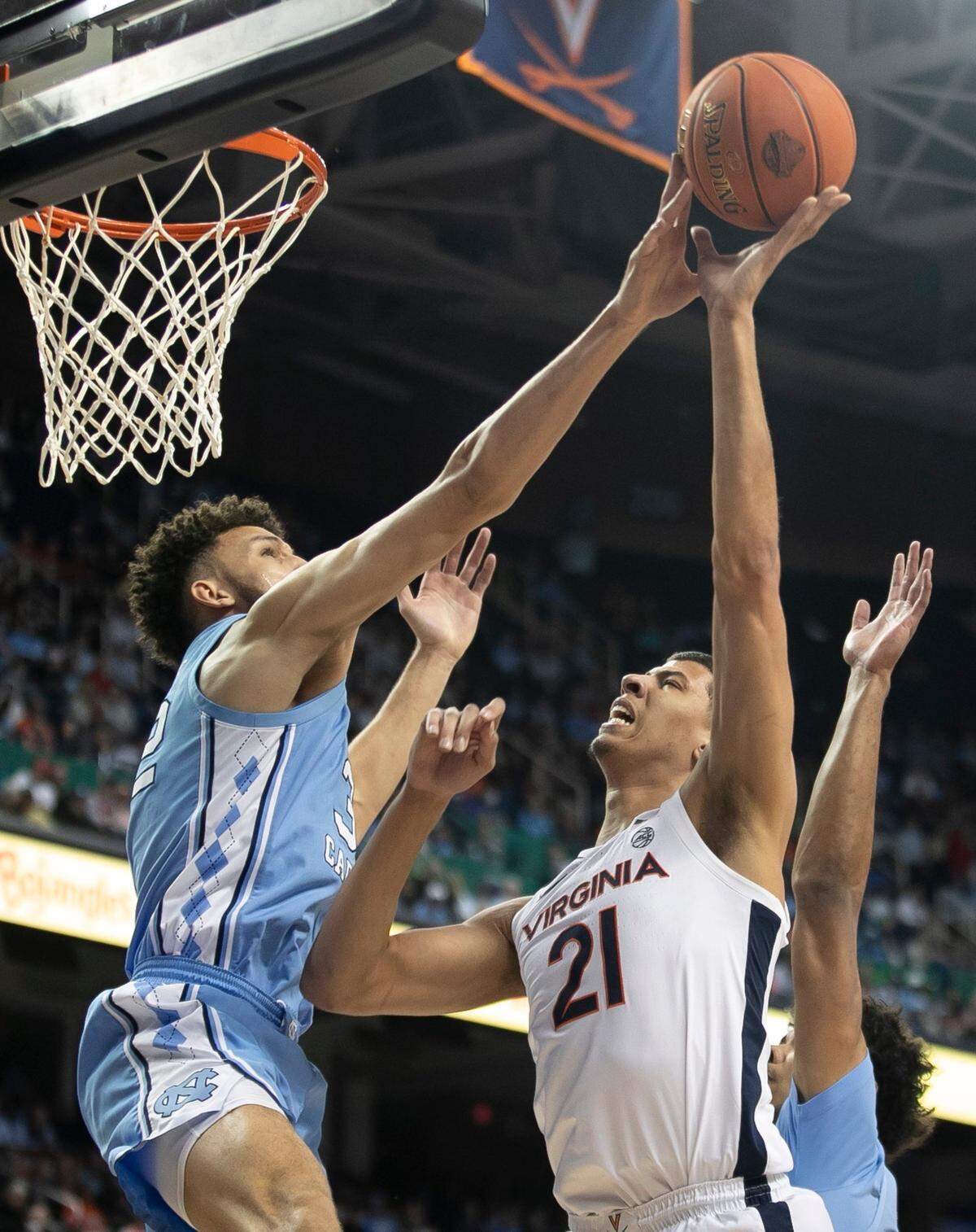 North Carolina’s Pete Nance (32) blocks a shot by Virginia’s Kadin Shedrick (21) in the first half during the third round of the ACC Tournament on Thursday, Marc