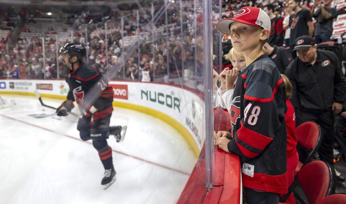 Chase Martinook and Henry Staal look for their fathers, Carolina Hurricanes players Jordan Martinook and Jordan Staal, from their ice level positions, at the pre-game skate on Monday May 4, 2026, at Lenovo Center in Raleigh, N.C. 