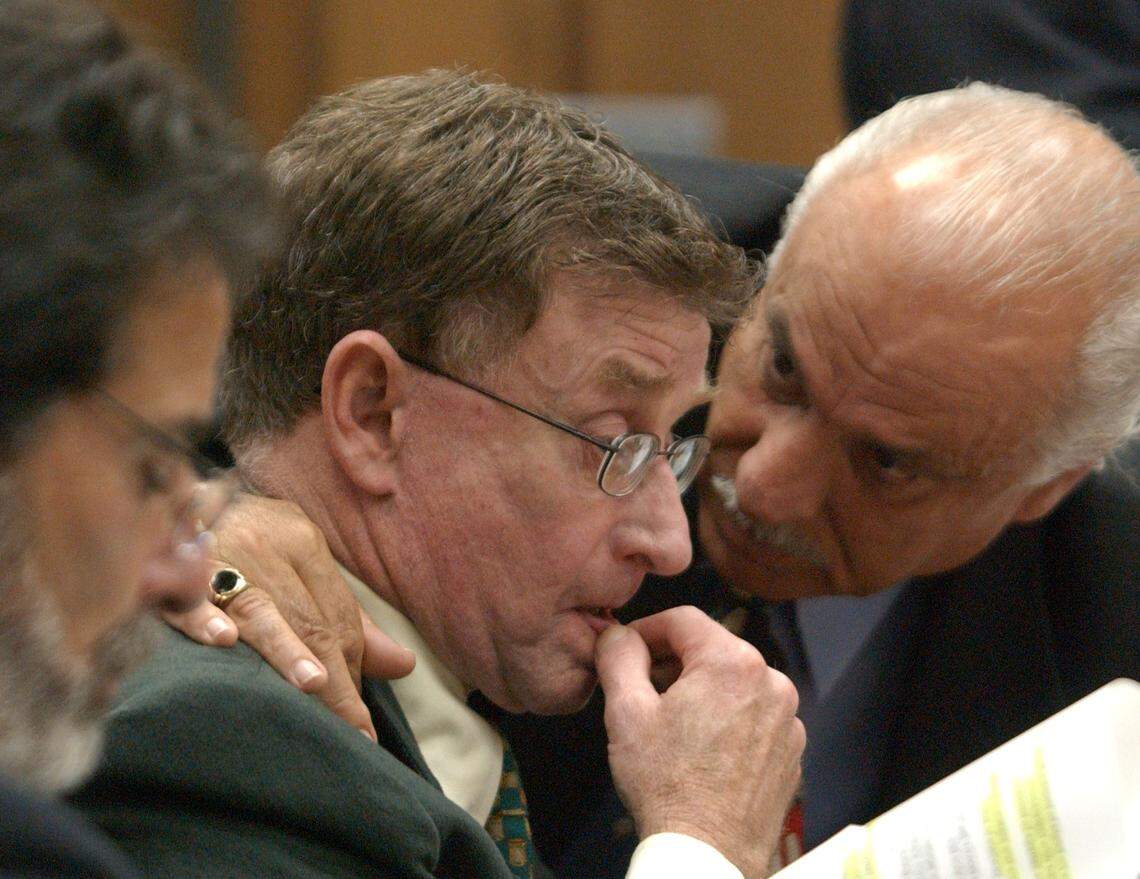 Murder defendant Michael Peterson, center, is comforted by defense team member Ron Guerette during closing arguments in Peterson’s 2003 murder trial.