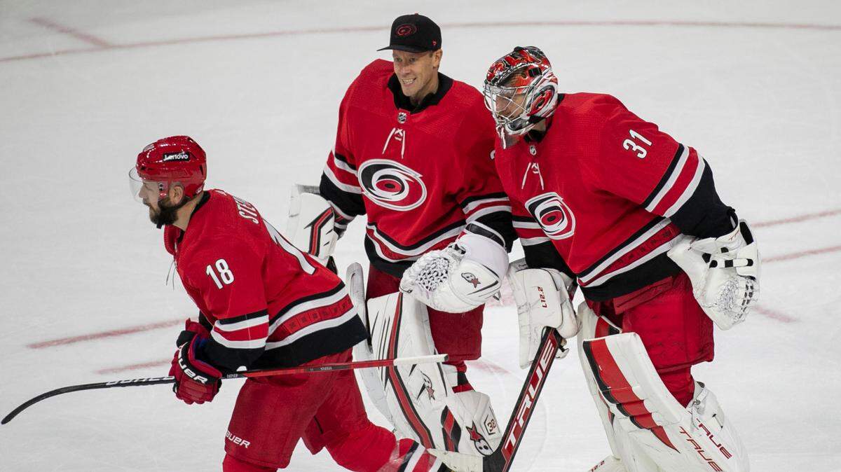 Carolina Hurricanes winning goalie Frederik Andersen (31) skates with Antii Raanta (32) as they celebrate their 6-3 victory over the New York Islanders on Thursday, October 14, 2021 at PNC Arena in Raleigh, N.C.