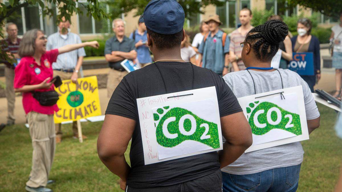 Demonstrators rally outside the Durham County courthouse Monday July 11, 2022 as the N.C. Utilities Commission travels across North Carolina, hearing public comments on a proposal that will guide how the state slashes emissions from the power sector.