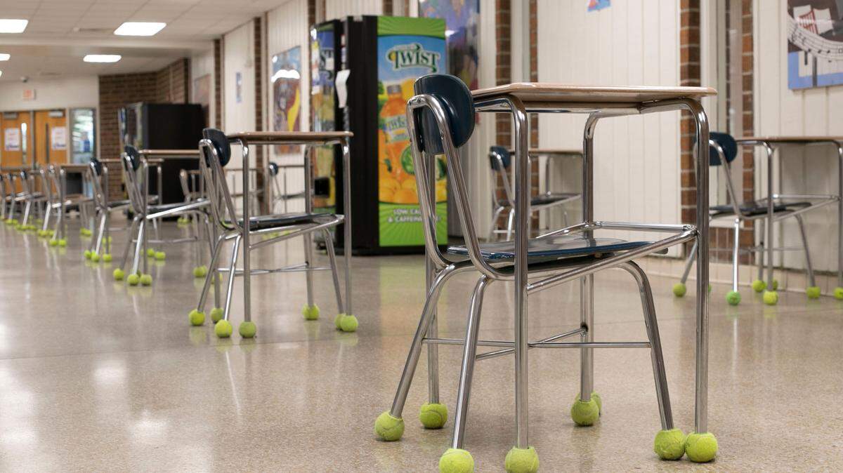 Tables and chairs are lined up, spaced out and facing in the same direction in the lunchroom of Athens Drive Magnet High School on Wednesday, February 10, 2020 in Raleigh, N.C. as they prepare to welcome back students for in-person classes next week. The number of people in the lunchroom will be limited and timed to prevent the possible spread of the COVID-19 virus.