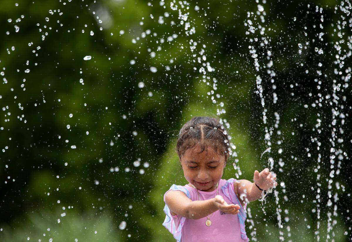 Monserrat Candela, 6, cools off in a splash pad at John Chavis Memorial Park on Tuesday, June 14, 2022, in Raleigh, N.C. Temperatures reached into the 90s across the Triangle on Tuesday.