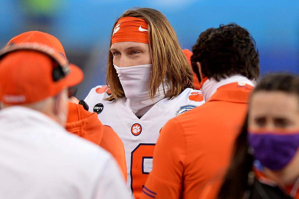 Clemson Tigers quarterback Trevor Lawrence is masked up as he discusses the game with personnel during second quarter action against Notre Dame at Bank of America Stadium on Saturday, December 19, 2020 in Charlotte, NC. The Clemson Tigers and Notre Dame Fighting Irish faced off in the ACC Championship game.