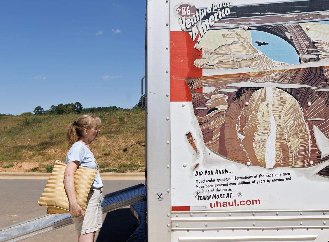 Jill Rohner holds pillows as she stands next to a moving truck outside her new home on Wednesday, Sept. 3, 2025. 
