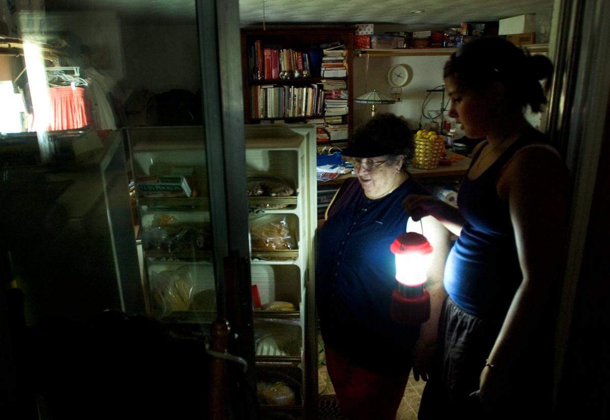 A Sacramento family without power for three days checks food in the freezer after their gas generator runs out fuel. SACRAMENTO BEE