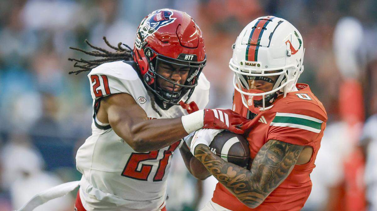 Miami Hurricanes wide receiver Keelan Marion (0) hauls in a first down reception as NC State Wolfpack cornerback Jamel Johnson (21) defends at Hard Rock Stadium in Miami Gardens, Florida, on Saturday, November 15, 2025. 