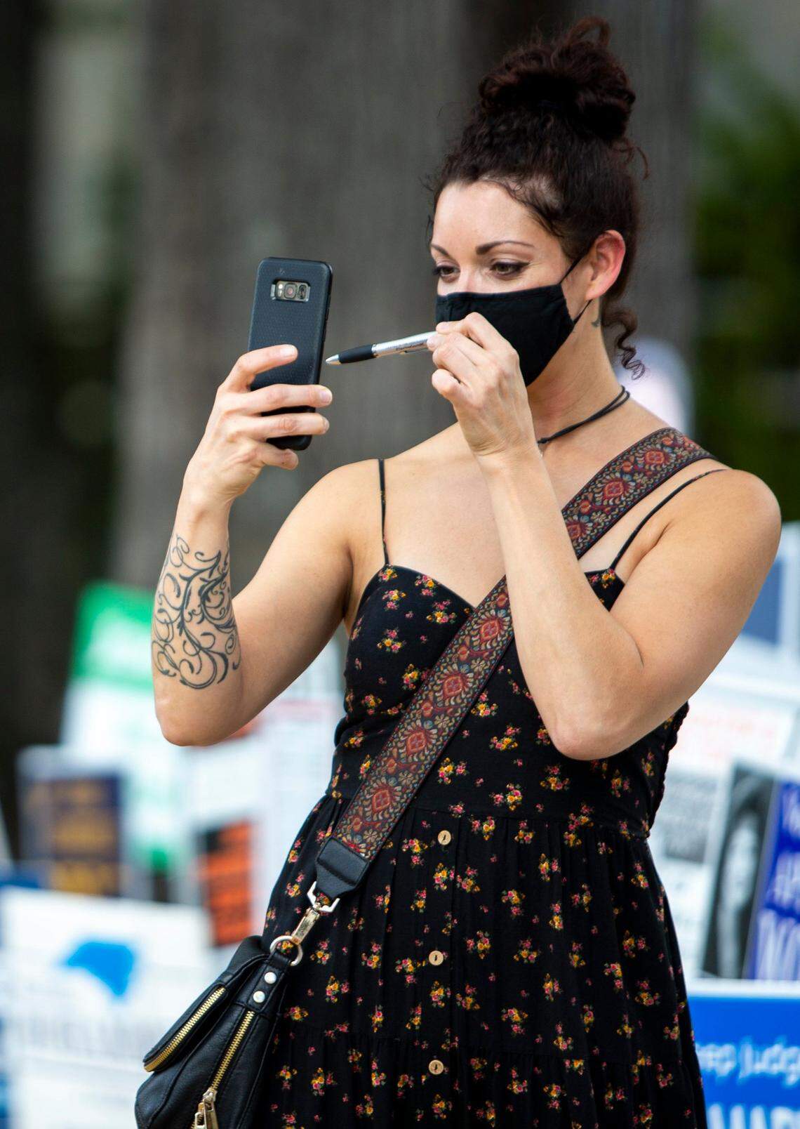 Angie Rivera holds up an “I voted” pen after voting early at The Bojangles Coliseum in Charlotte, NC on Friday, October 23, 2020. Rivera said she had voted early for only one other election but made sure to vote early for this election.