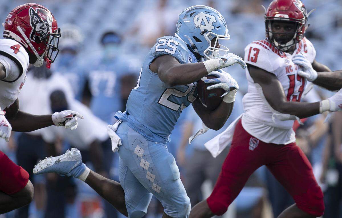 North Carolina’s Javonte Williams (25) scores on a 27-yard run in the fourth quarter to give the Tar Heels’ a 45-14 lead over N.C. State in the fourth quarter at Kenan Stadium on Saturday, October 24, 2020 in Chapel Hill, N.C.