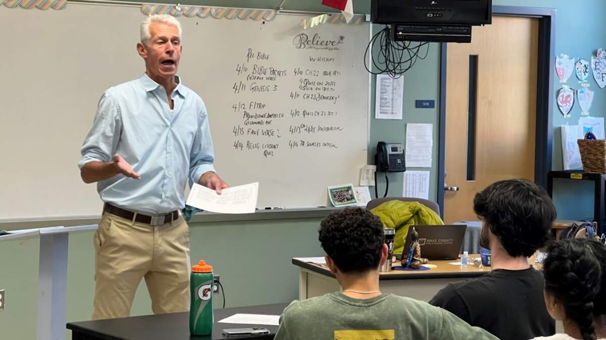 Paul Dinkenor, Leesville Road’s inaugural “World Religions and the Bible in History” teacher, provides focused instruction to students, from left, Alan Davila, John Mark Shaw, and Ishika Verna.
