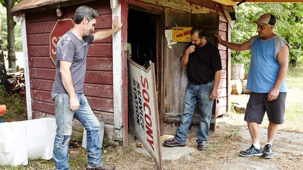 Mike Wolfe, left, and Frank Fritz, center, inspect an item for the History Channel TV show “American Pickers.”