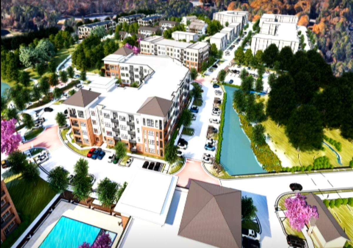 A bird’s eye view of Hillmont, at Barbee Chapel Road and NC 54, shows three apartment buildings at the development’s core (left, front) with the approved Barbee Chapel Apartments in the background. A restored stream is at bottom right.