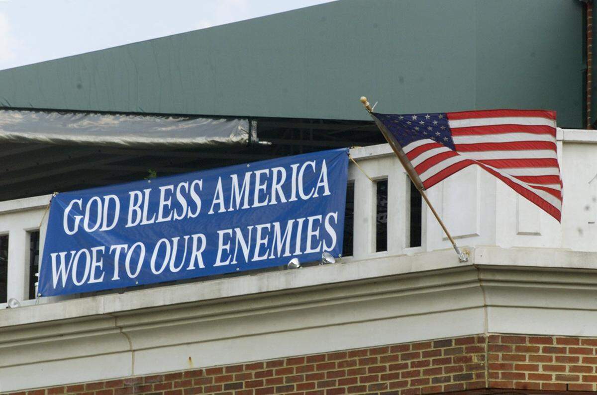 A flag and banner proclaiming “God Bless America, Woe to Our Enemies” are displayed at Top of the Hill Restaurant in Chapel Hill, N.C., Wednesday, Sept. 12, 2001. Zoning inspectors made the restaurant owner remove a banner after at least three town council members complained.