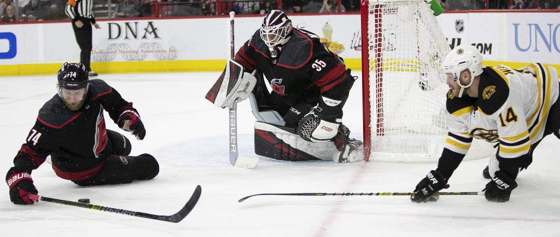 Carolina Hurricanes’ Jaccob Slavin (74) protects the puck from Boston Bruins’ Chris Wagner(14) in front of Hurricanes’ goalie Curtis McElhinney (35) during the second period of Game 3 of the Eastern Conference finals on Tuesday, May 14, 2019 at PNC Arena in Raleigh, N.C.