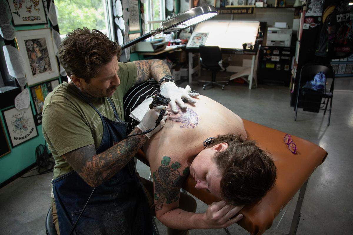 Mike Wheeler, owner of Easy Tiger Custom Tattoo in Durham, tattoos Erin Barringer on Wednesday, June 21, 2023.