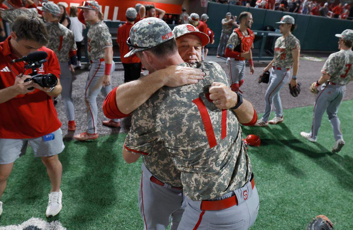 N.C. State head coach Elliott Avent hugs Sam HIghfill (17) after N.C. State’s 5-3 victory over James Madison in the NCAA Raleigh Regional final at Doak Field Sunday, June 2, 2024.