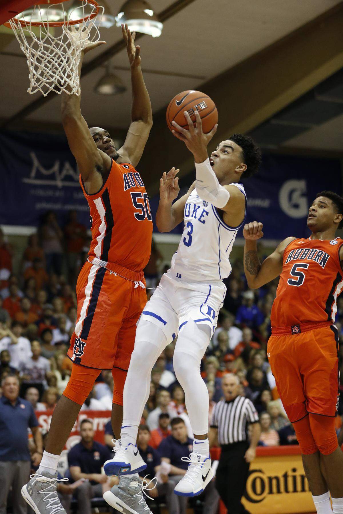 Duke guard Tre Jones (3) splits Auburn center Austin Wiley (50) and forward Chuma Okeke (5) to go at the basket during the first half at the Maui Invitational, Tuesday, Nov. 20, 2018, in Lahaina, Hawaii. 