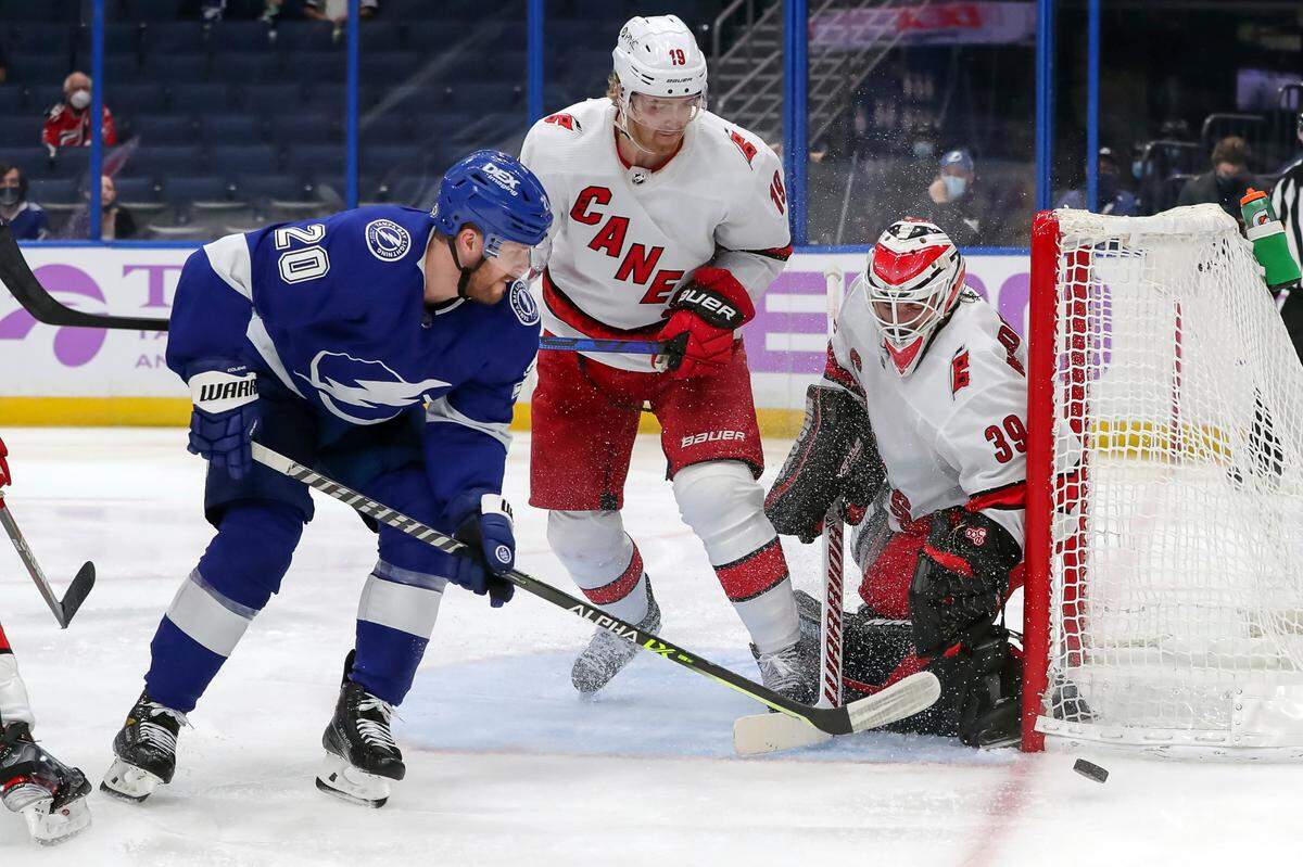Carolina Hurricanes goaltender Alex Nedeljkovic (39) makes a save against Tampa Bay Lightning’s Blake Coleman as Dougie Hamilton (19) defends during the second period of an NHL hockey game Tuesday, April 20, 2021, in Tampa, Fla. (AP Photo/Mike Carlson)