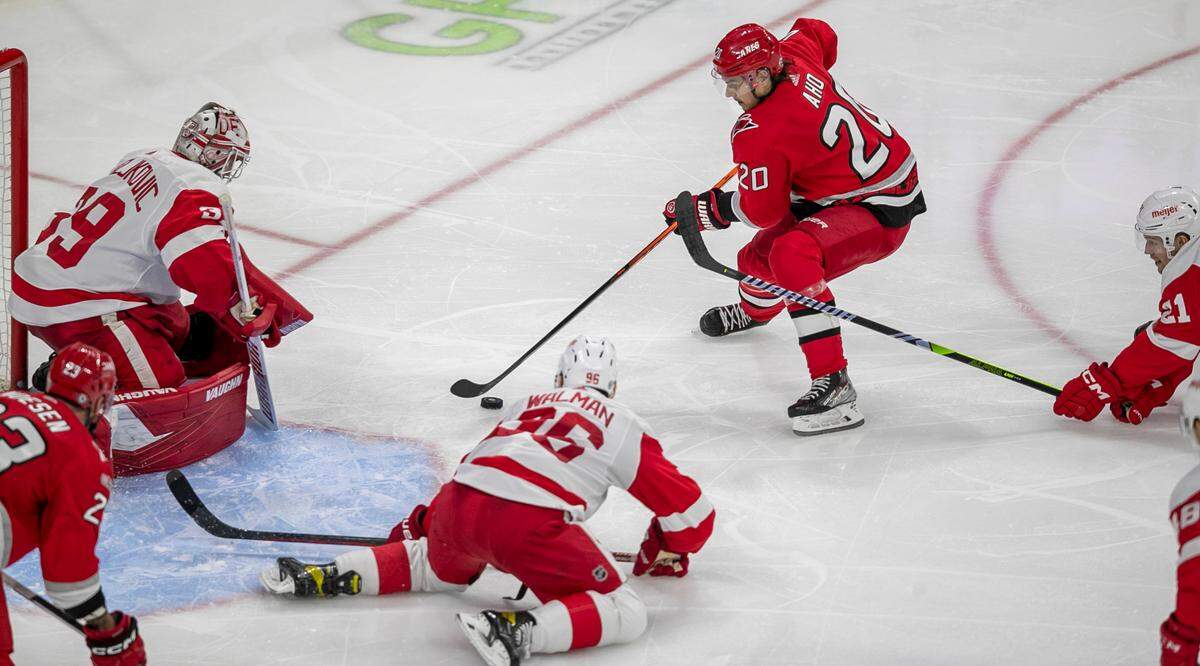 Carolina Hurricanes’ Sebastian Aho (20) works the puck against Detroit’s Jake Walman (96) and goalie Alex Nedeljkovic (39) in the third period on Tuesday, April 11, 2023 at PNC Arena in Raleigh, N.C.