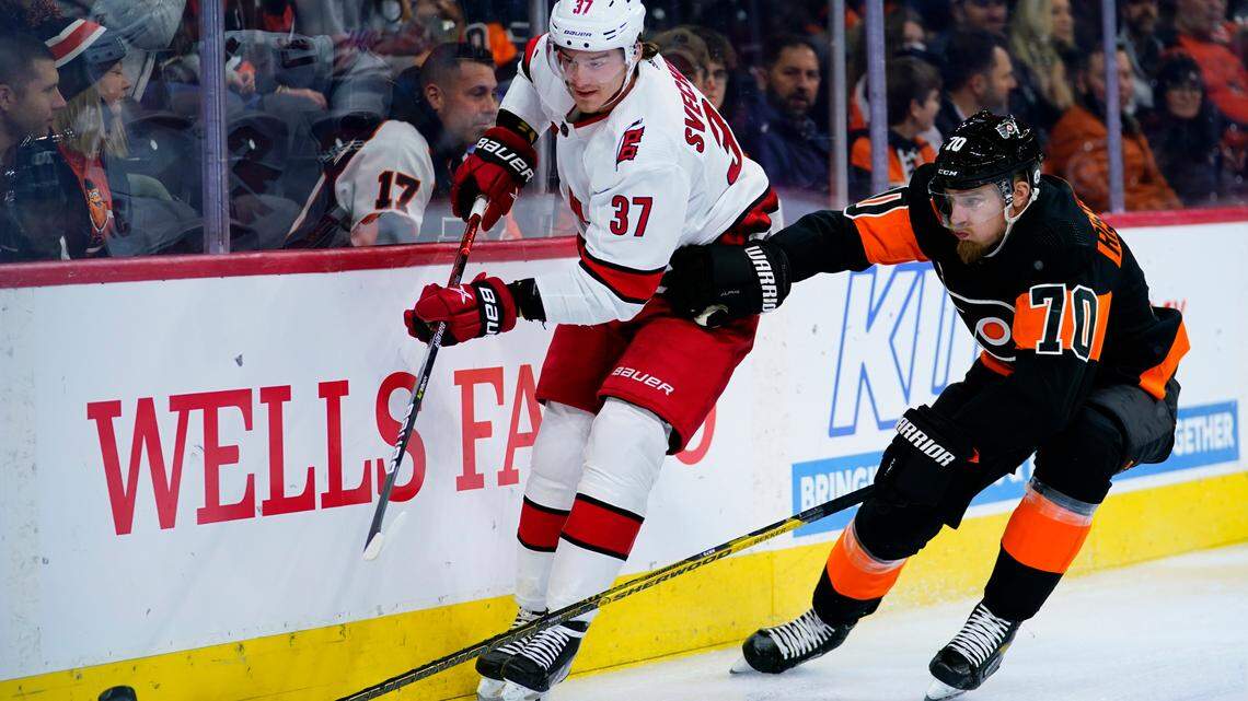Carolina Hurricanes’ Andrei Svechnikov, left, clears the puck away from Philadelphia Flyers’ Rasmus Ristolainen during the first period of an NHL hockey game, Friday, Nov. 26, 2021, in Philadelphia. (AP Photo/Matt Slocum)