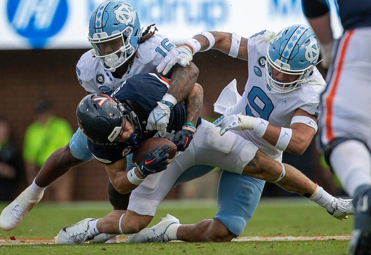 North Carolina’s Cam’Ron Kelly (9) and DeAndre Boykins (16) defend Virginia’s Billy Kemp IV (4) in the fourth quarter on Saturday, November 5, 2022 at Scott Stadium in Charlottesville, Va.