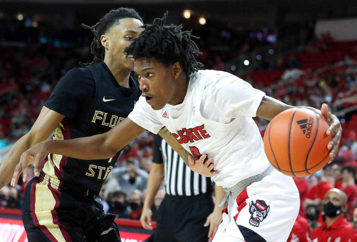 N.C. State’s Terquavion Smith (0) drives past Florida State’s Caleb Mills (4) during the second half of Florida State’s 83-81 victory over N.C. State at PNC Arena in Raleigh, N.C., Saturday, Jan. 1, 2022.
