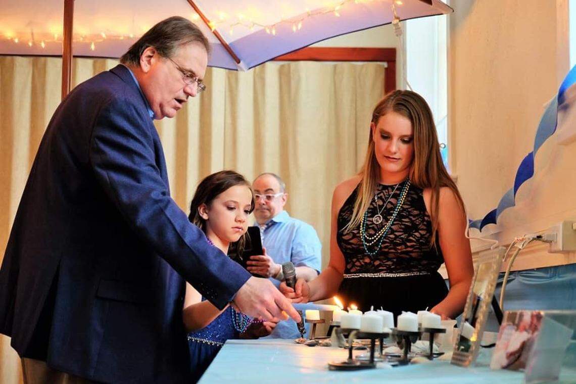 Eli Klausner, left, and his granddaughters Fiona, middle, and Lily, right, at Lily’s bat bitzvah in 2018. Klausner died of COVID-19-related complications April 13.