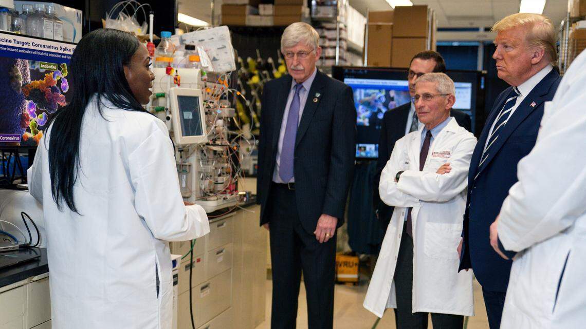 In this Tuesday, March 3, 2020 file photo, Dr. Kizzmekia Corbett, left, senior research fellow and scientific lead for coronavirus vaccines and immunopathogenesis team in the Viral Pathogenesis Laboratory, talks with President Donald Trump as he tours the Viral Pathogenesis Laboratory at the National Institutes of Health in Bethesda, Md. Dozens of research groups around the world are racing to create a vaccine as COVID-19 cases continue to grow.