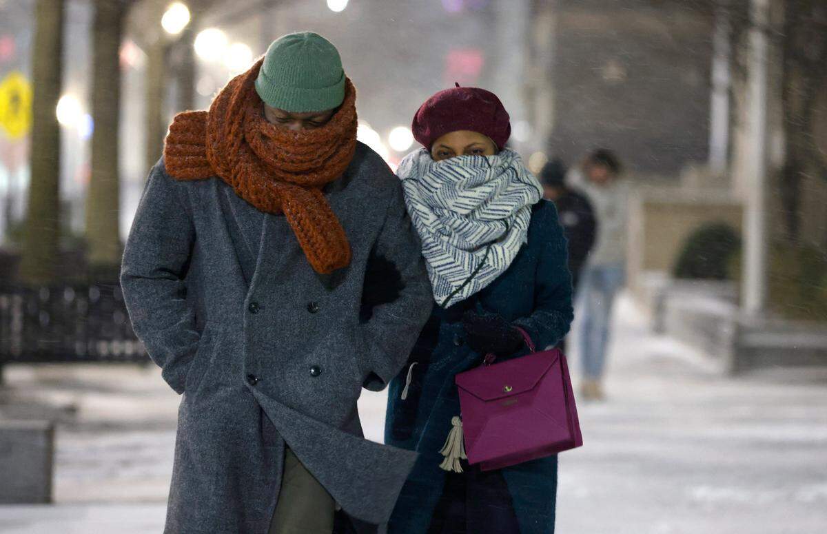 Yasmin Johnson and her boyfriend Nelson Jenkins walk down Fayetteville Street in downtown Raleigh during the evening snow Friday, Jan. 21, 2022.