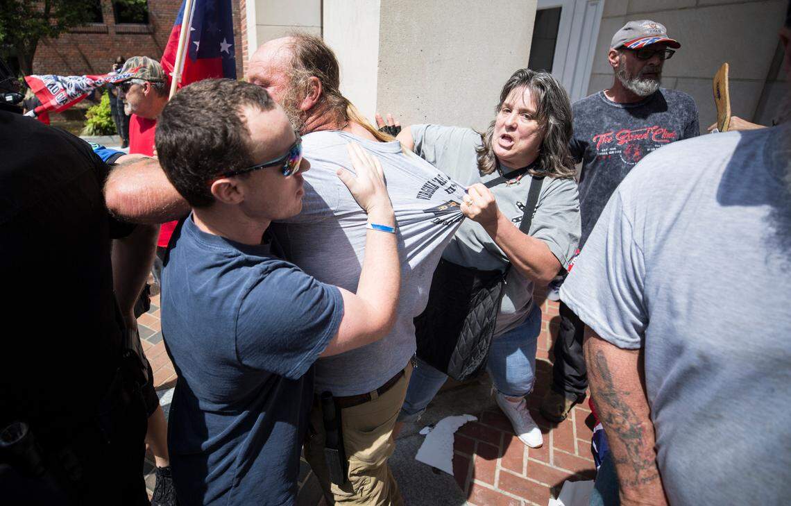 Wendy Hayslett, right, and Ryan Barnett, left, pull Richard Hayslett Sr. away from a scuffle on the steps of Peace and Justice Plaza in Chapel Hill, NC on Saturday, May 4, 2019. Barnett has been charged with misdemeanor vandalism and ethnic intimidation in connection with the vandalism of UNC’s Unsung Founders Memorial, which is dedicated to slaves and African-American workers.