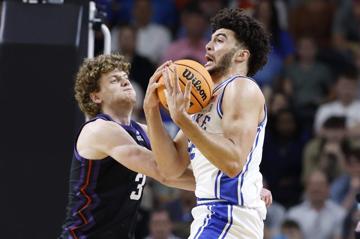 Duke’s Cameron Boozer (12) pulls in the rebound TCU’s Liutauras Lelevicius (3) during the first half of Duke’s game against TCU in the second round of the NCAA Men’s Basketball Tournament at  Bon Secours Wellness Arena in Greenville, S.C., Saturday, March 21, 2026.