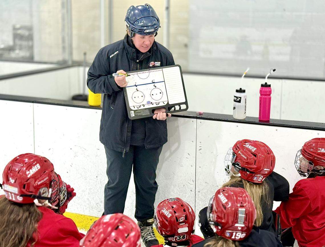Hockey coach Jessica Hughes goes over drill instructions at a Junior Canes Girls 10U Red practice at Invisalign Arena at Wake Competition Center in Morrisville, N.C., on Thursday, Jan. 29, 2026.