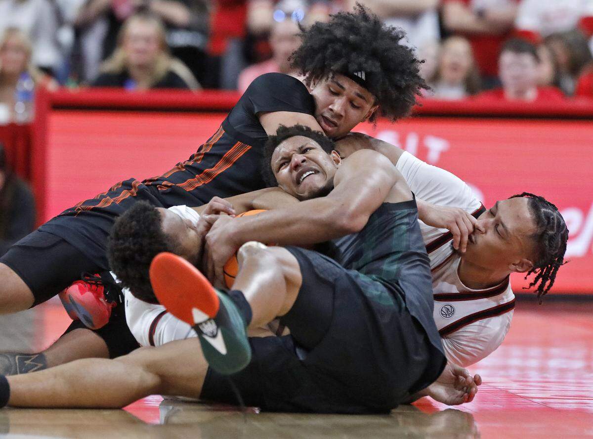 N.C. State’s Quadir Copeland and Darrion Williams scramble for a loose ball with Miami’s Tre Donaldson and Malik Reneau during the second half of the Wolfpack’s 77-76 loss on Saturday, Feb. 14, 2026, at Lenovo Center in Raleigh, N.C. 