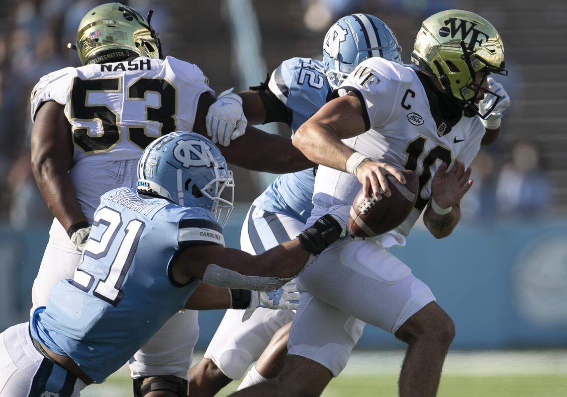 Wake Forest quarterback Sam Hartman (10) scrambles away from North Carolina linebacker Chazz Surratt (21) in the third quarter at Kenan Stadium on Saturday, November 14, 2020 in Chapel Hill, N.C.
