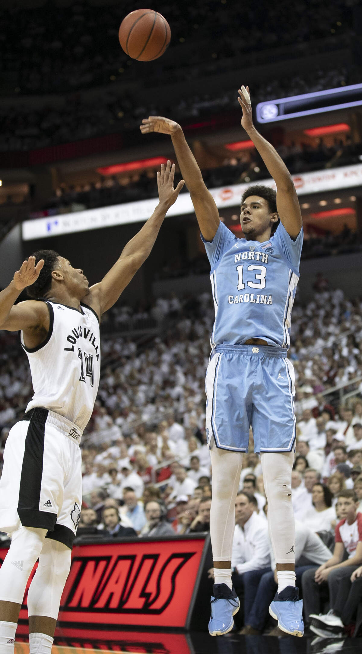 North Carolina’s Cameron Johnson (13) launches a three-point shot over Louisville’s Dwayne Sutton (24) during the first half on Saturday, February 2, 2019 at the KFC Yum! Center in Louisville, Ky. Johnson had 19 points in the Tar Heels’ victory.