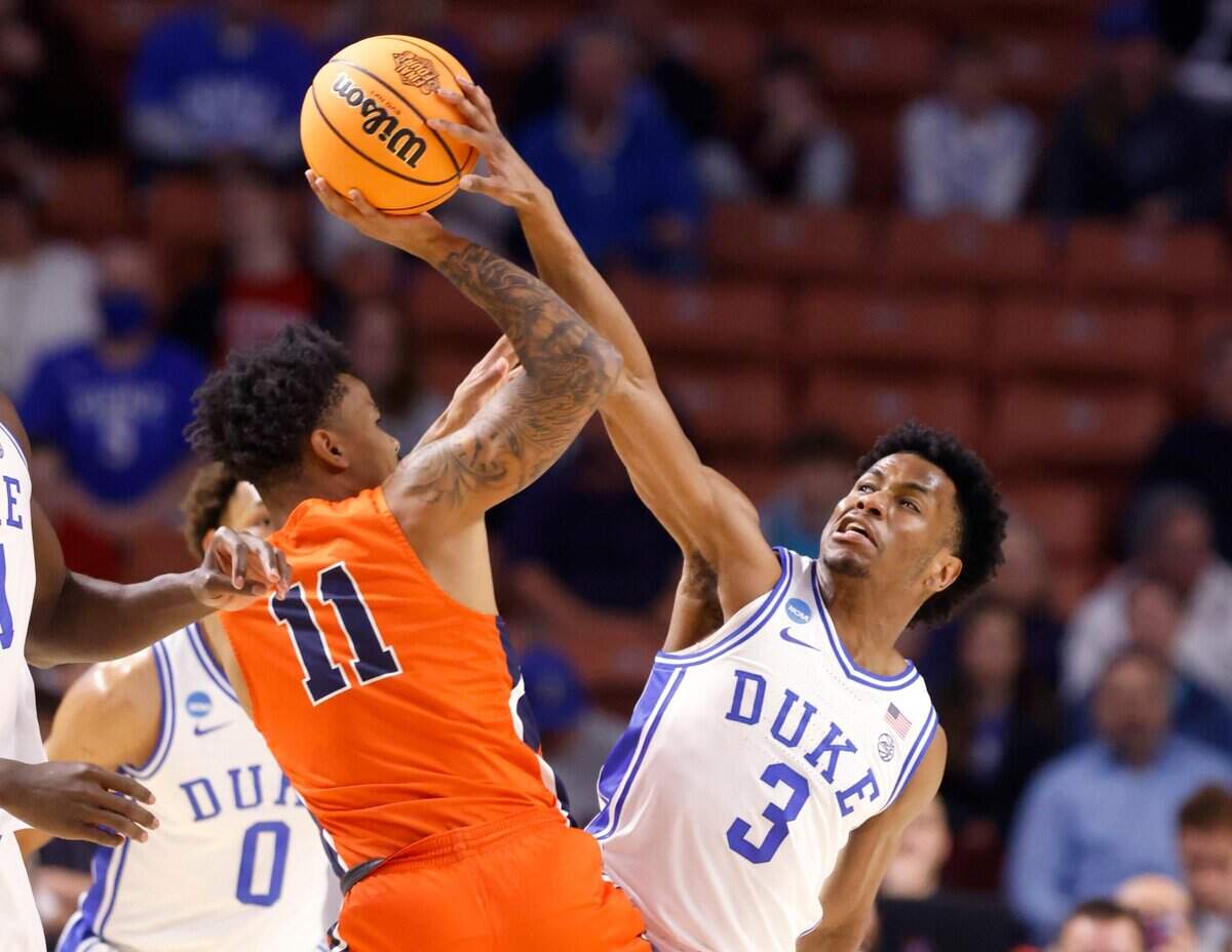 Dukes Jeremy Roach (3) blocks the shot by Cal State Fullerton’s Damari Milstead (11) during the first half of Dukes game against Cal State Fullerton in the first round of the NCAA Tournament at Bon Secours Wellness Arena in Greenville, S.C., Friday, March 18, 2022.