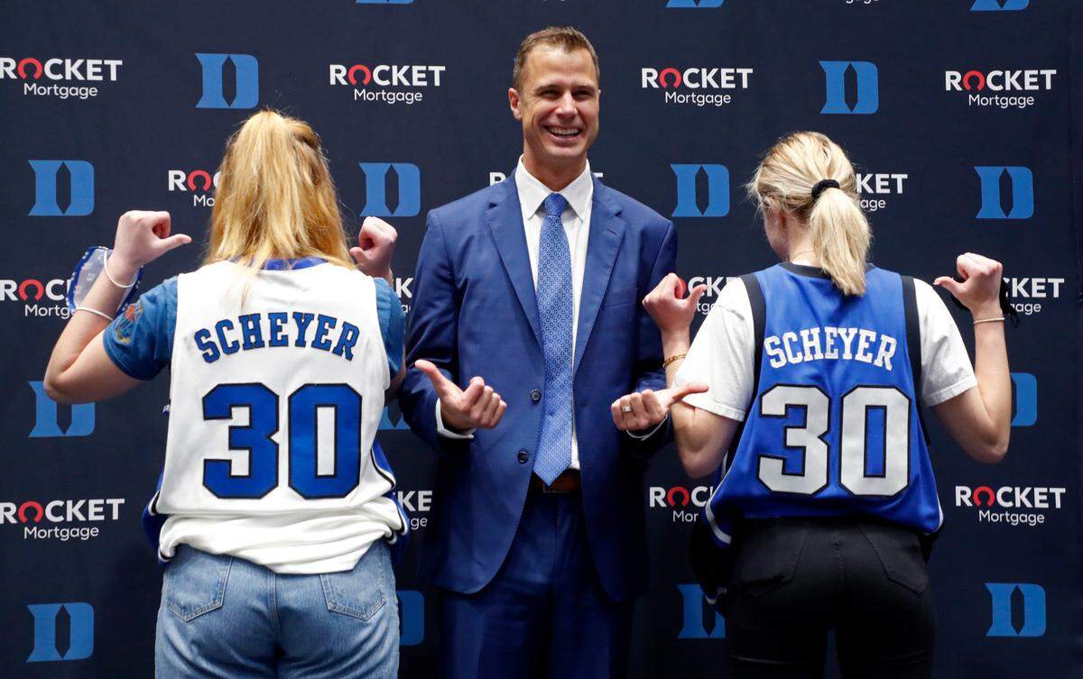 Jon Scheyer poses with Carly Savarino, left, and her sister, Emmie, after a press conference where Scheyer was introduced as Duke basketball’s 20th head coach at Cameron Indoor Stadium in Durham, N.C., Friday, June 4, 2021. Carly and Emmie Savarino are grandchildren of coach Mike Krzyzewski.