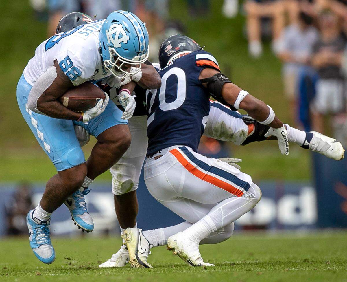 North Carolina’s Kamari Morales (88) is stopped by Virginia’s Jonas Sanker (20) after a 15-yard pass reception from quarterback Drake Maye (10) in the second quarter on Saturday, November 5, 2022 at Scott Stadium in Charlottesville, Va.