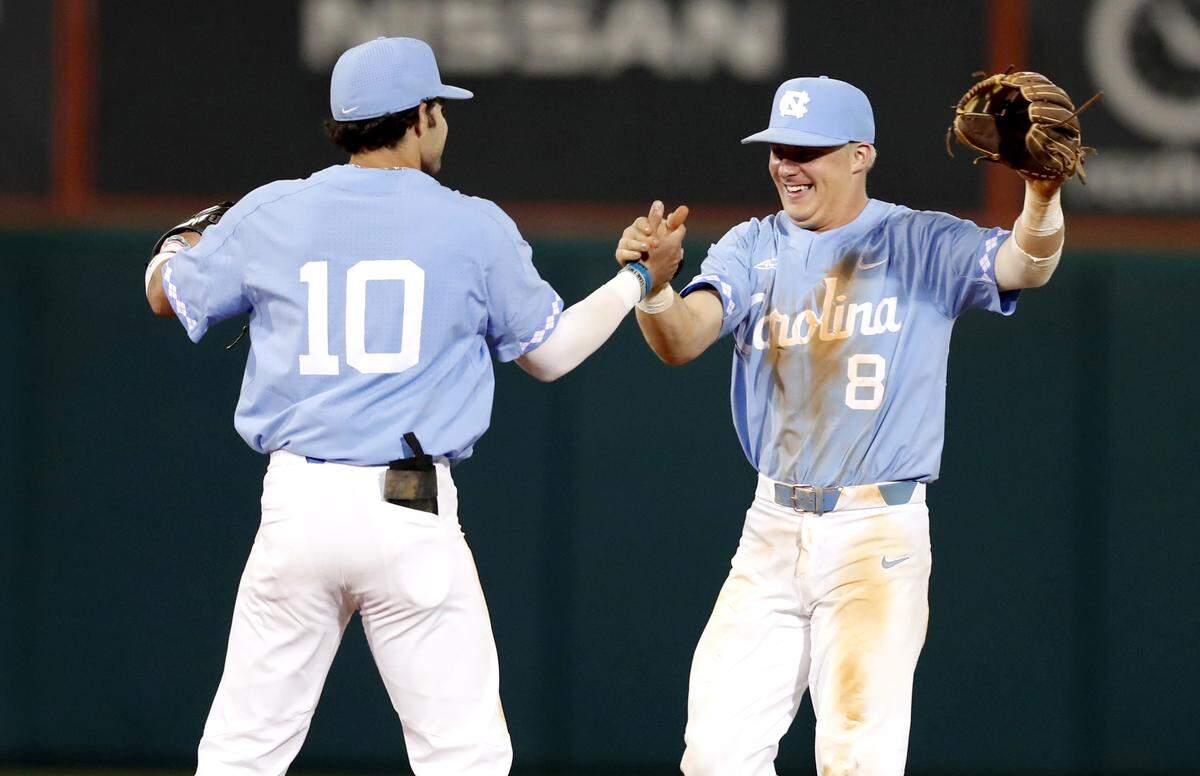 North Carolina's Ike Freeman (8) and Zack Gahagan (10) celebrate after UNC's 6-5 victory over N.C. State at Doak Field Friday, April 27, 2018.